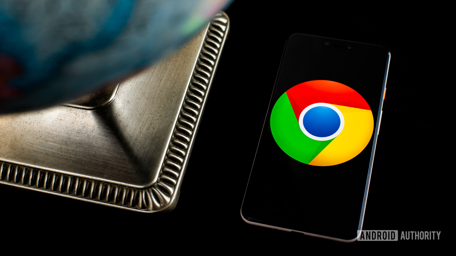Chrome-Logo auf Smartphone neben Globus